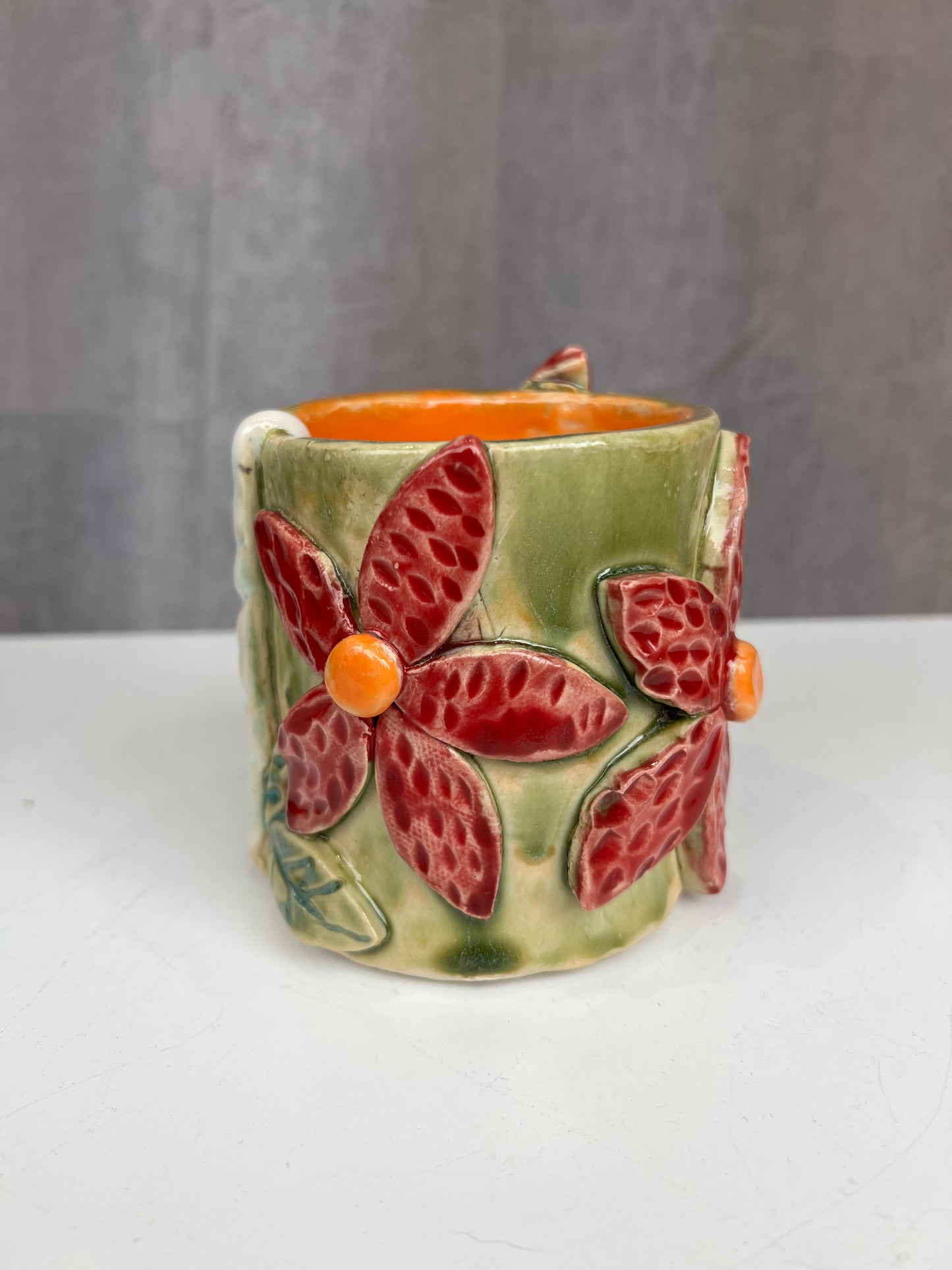 Green and red flower handle-less mug