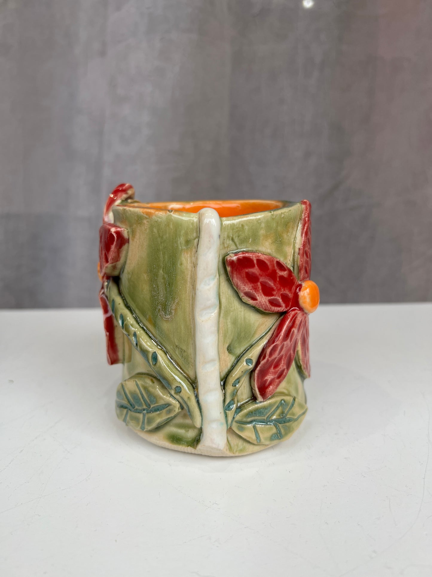 Green and red flower handle-less mug