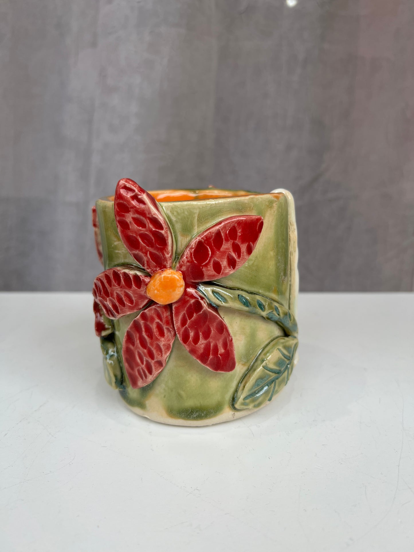 Green and red flower handle-less mug